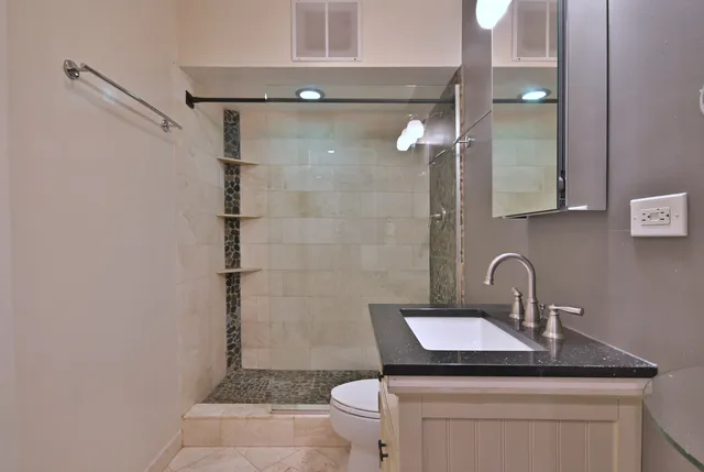 a bathroom with a sink a toilet and shower