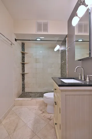 a bathroom with a sink a toilet and shower