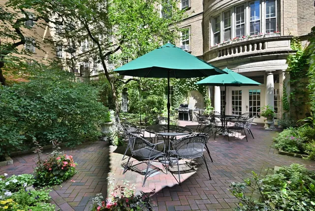 a view of a patio with table and chairs under an umbrella
