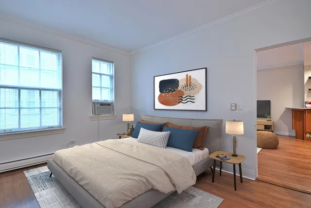 a bedroom with a bed and wooden floor