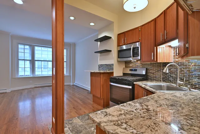a kitchen with stainless steel appliances granite countertop a sink stove microwave and wooden floor