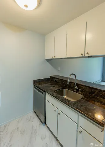 a kitchen with granite countertop a sink and cabinets