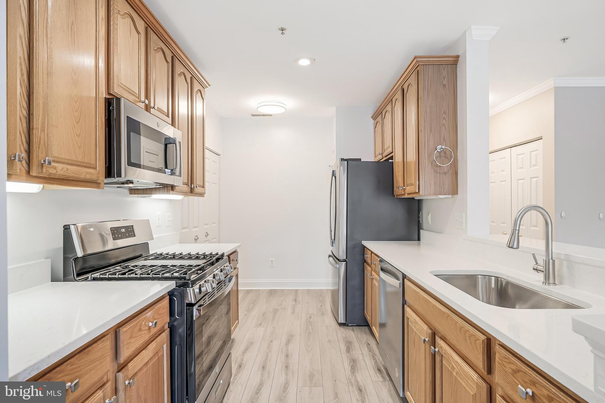 25280 Lake Shore Square, Unit 102 Chantilly, VA 20152 - Photo 12 of 41 a kitchen with stainless steel appliances granite countertop a sink stove and refrigerator