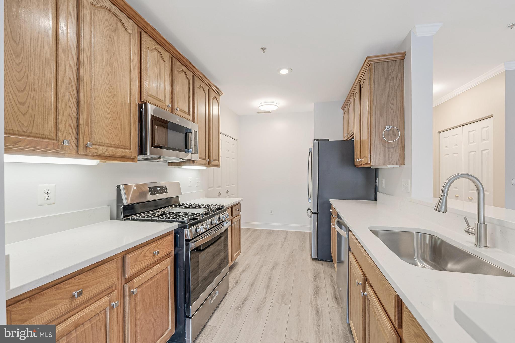 25280 Lake Shore Square, Unit 102 Chantilly, VA 20152 - Photo 13 of 41 a kitchen with stainless steel appliances granite countertop a sink stove and refrigerator