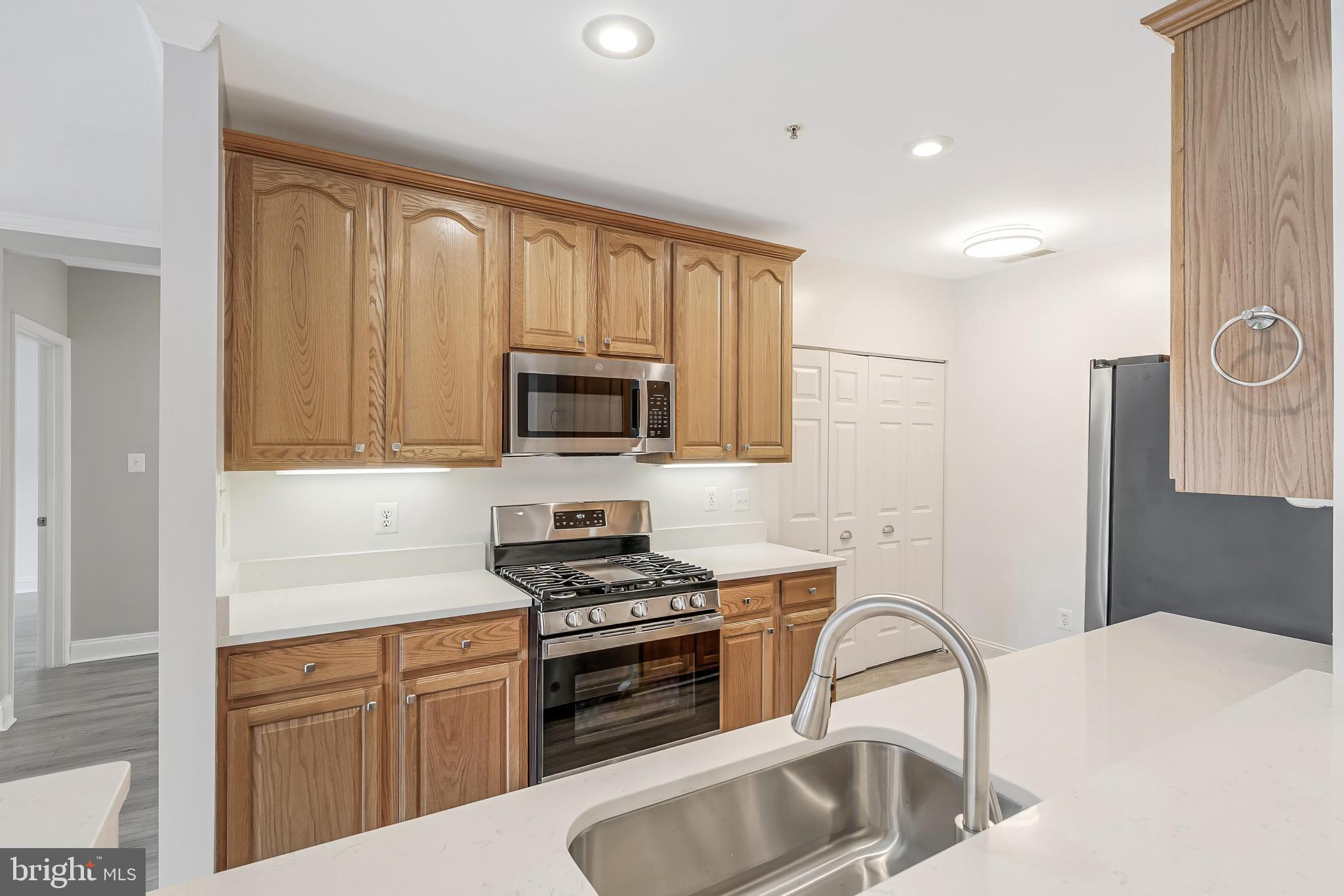 25280 Lake Shore Square, Unit 102 Chantilly, VA 20152 - Photo 14 of 41 a kitchen with granite countertop a sink stainless steel appliances and cabinets