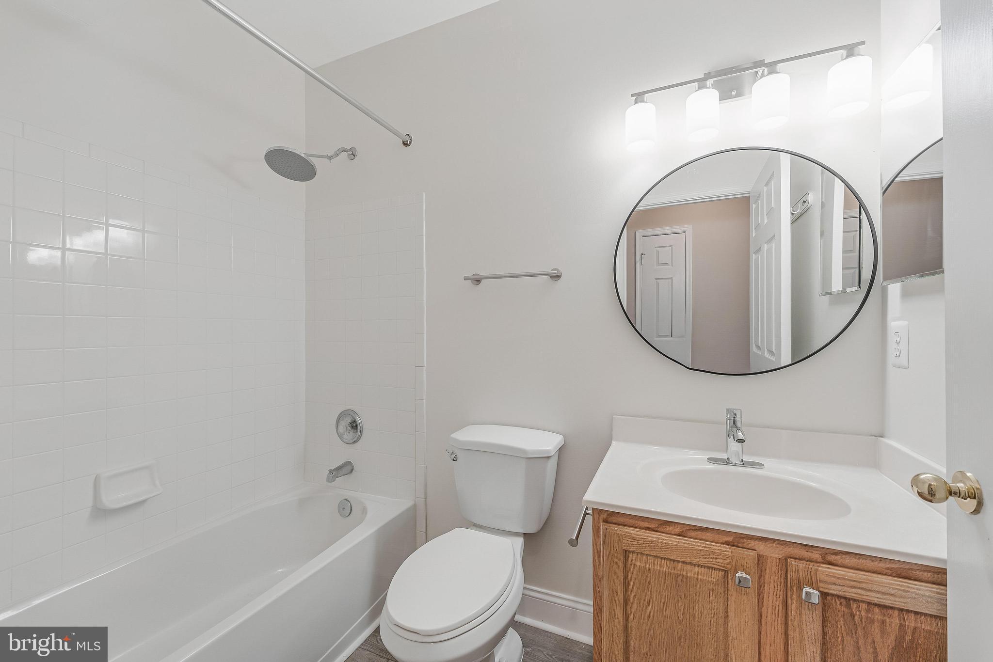 25280 Lake Shore Square, Unit 102 Chantilly, VA 20152 - Photo 19 of 41 a bathroom with a granite countertop toilet a sink and a mirror