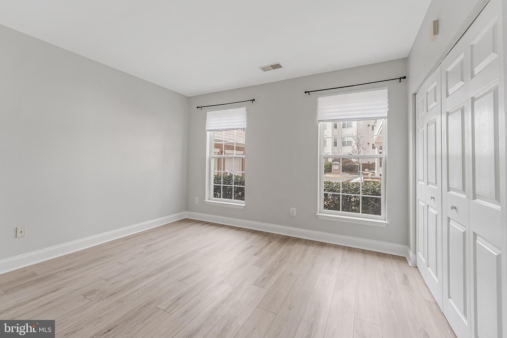 25280 Lake Shore Square, Unit 102 Chantilly, VA 20152 - Photo 20 of 41 an empty room with wooden floor and windows