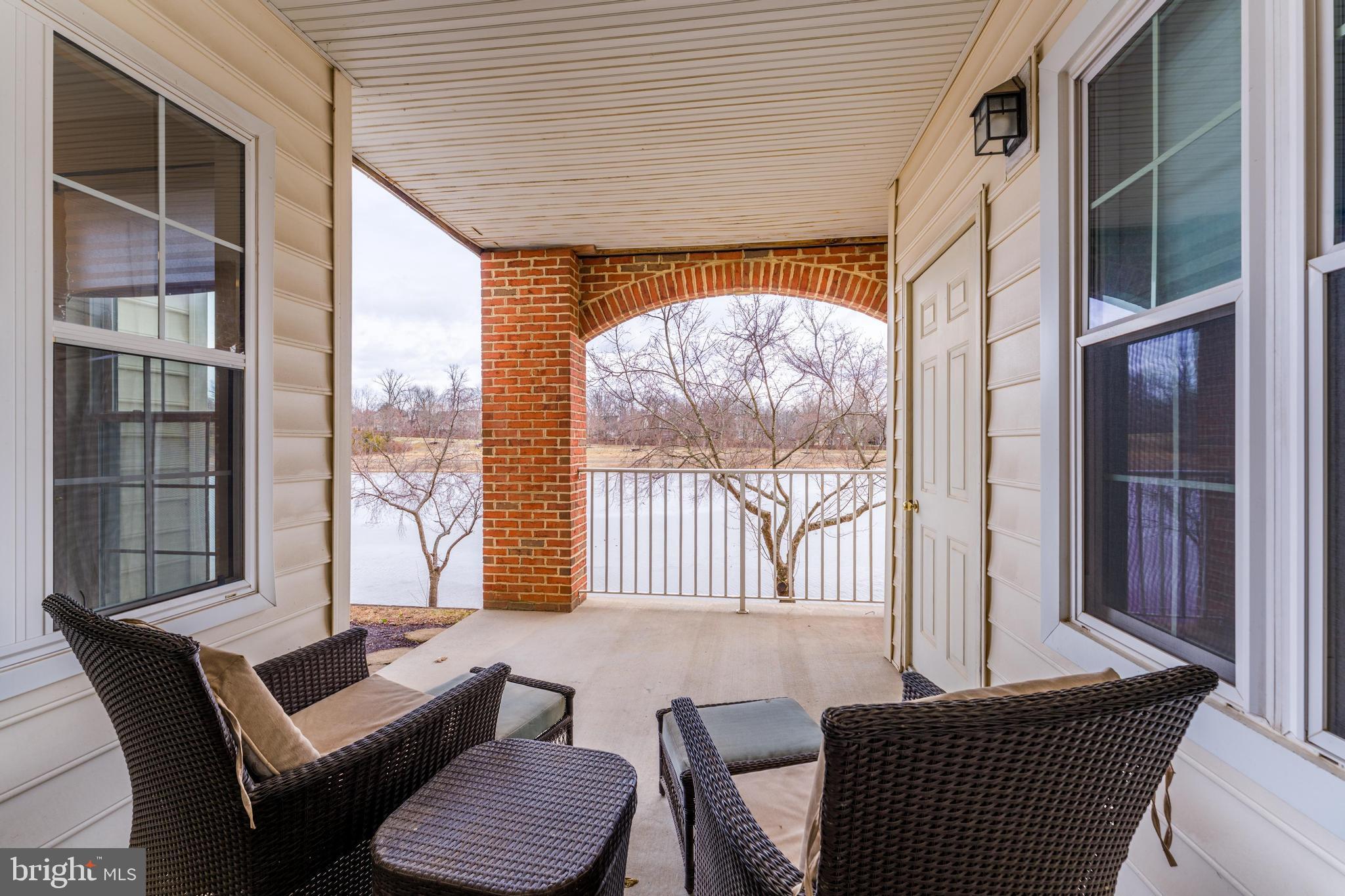 25280 Lake Shore Square, Unit 102 Chantilly, VA 20152 - Photo 29 of 41 a living room with furniture and a floor to ceiling window