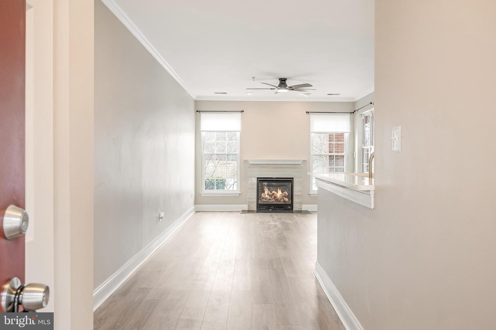 25280 Lake Shore Square, Unit 102 Chantilly, VA 20152 - Photo 3 of 41 a view of an empty room with wooden floor and a window