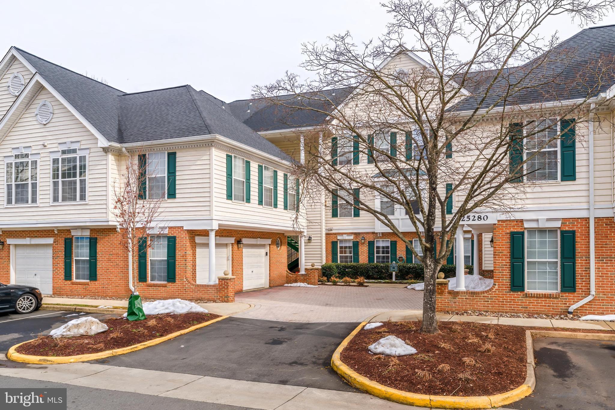 25280 Lake Shore Square, Unit 102 Chantilly, VA 20152 - Photo 34 of 41 a front view of a house with a garden and plants