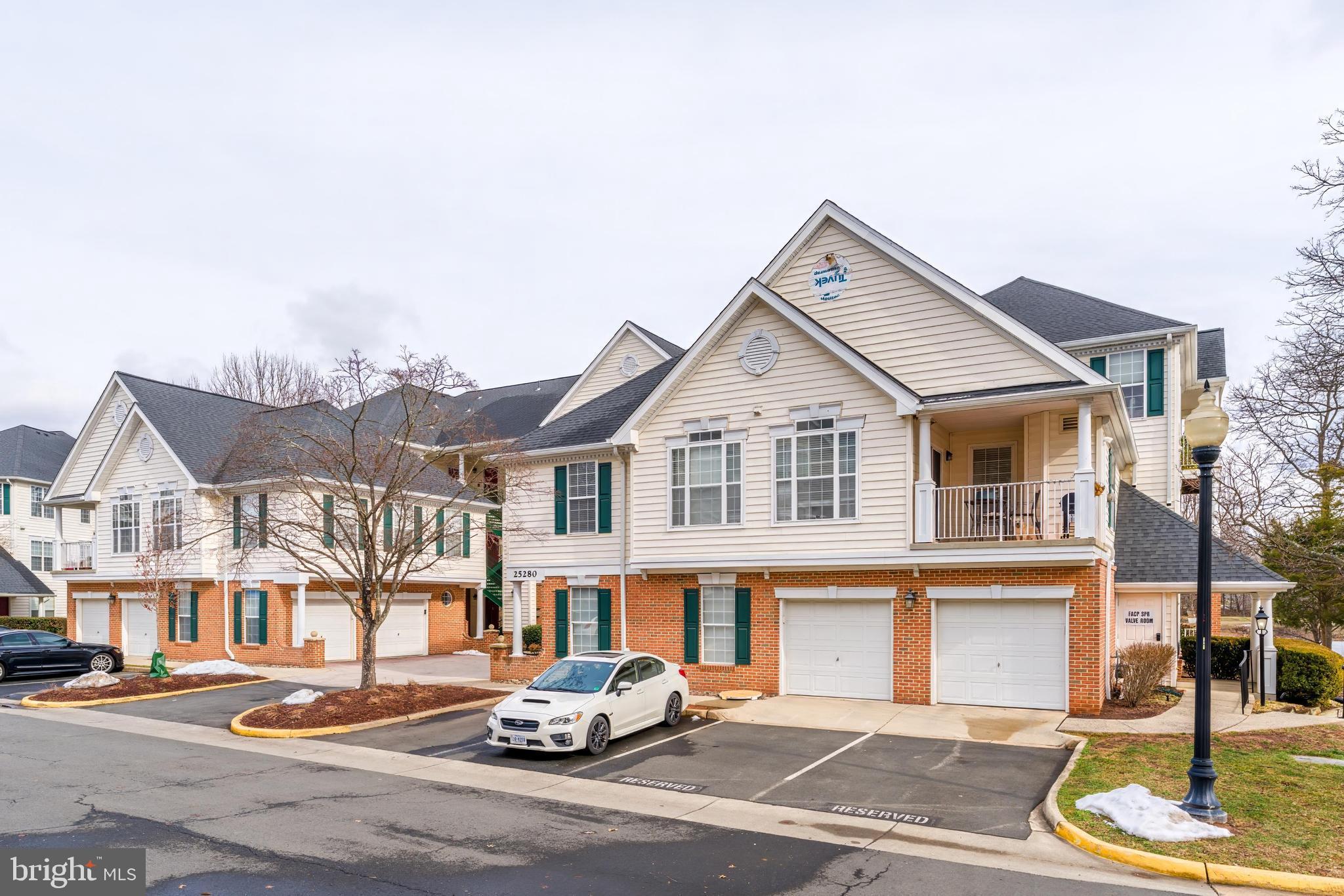 25280 Lake Shore Square, Unit 102 Chantilly, VA 20152 - Photo 35 of 41 a front view of a residential apartment building with garage and parking