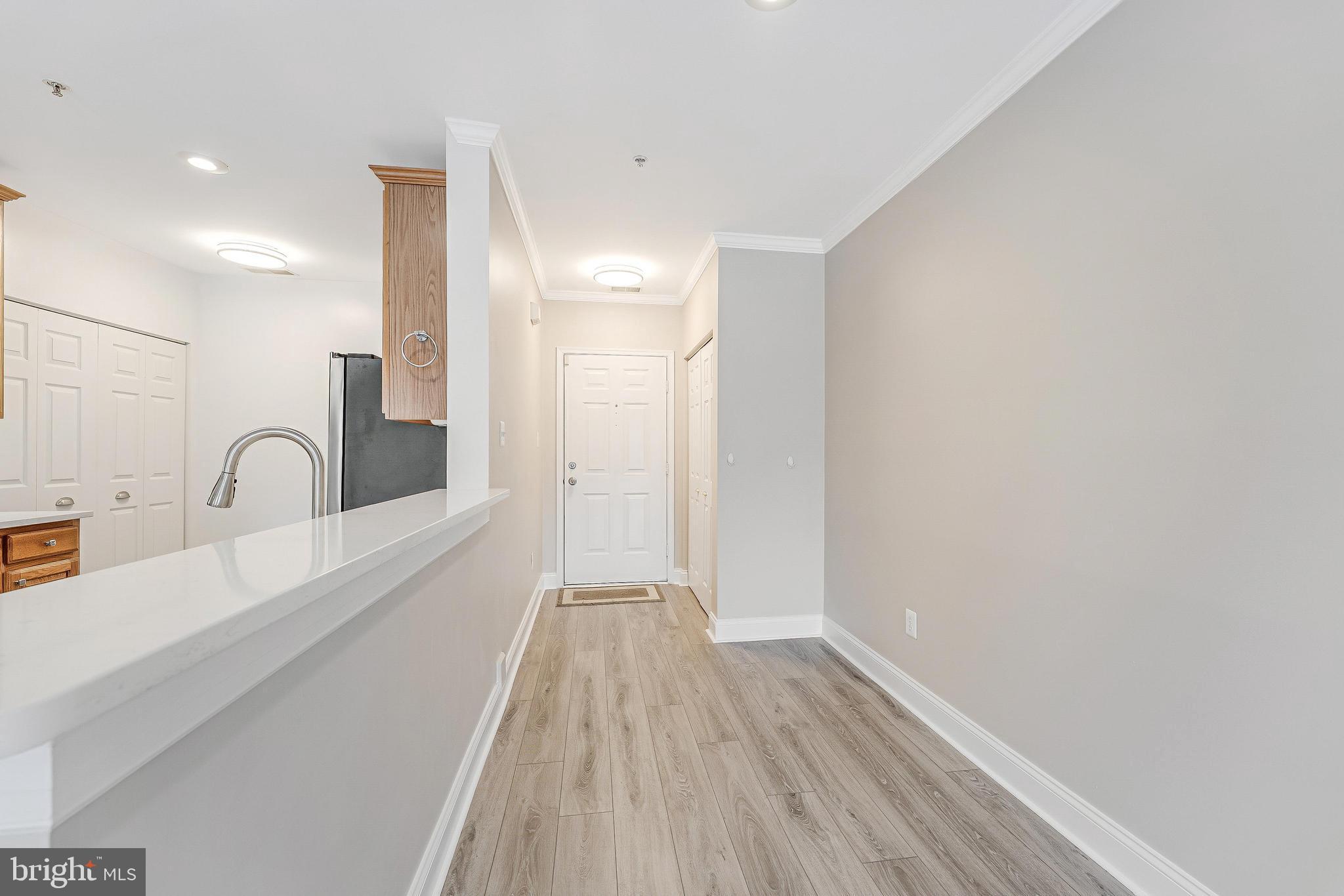 25280 Lake Shore Square, Unit 102 Chantilly, VA 20152 - Photo 5 of 41 a view of a kitchen with a sink and wooden floor