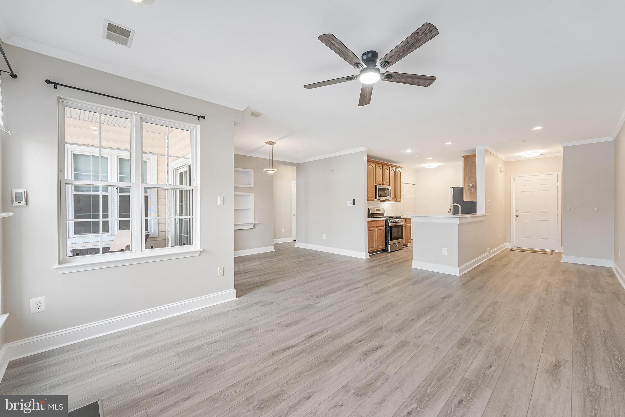 25280 Lake Shore Square, Unit 102 Chantilly, VA 20152 - Photo 7 of 41 a view of an empty room with wooden floor and a window
