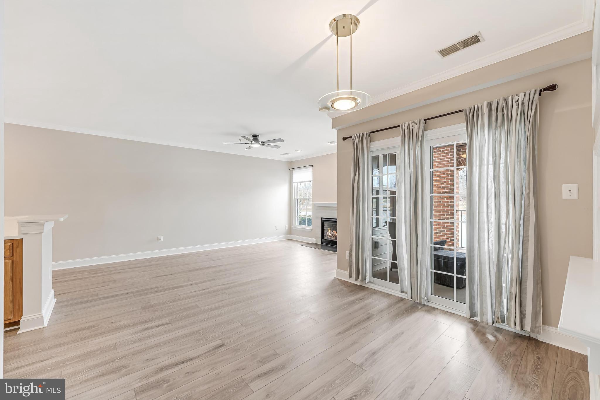 25280 Lake Shore Square, Unit 102 Chantilly, VA 20152 - Photo 9 of 41 a view of empty room with wooden floor and fireplace