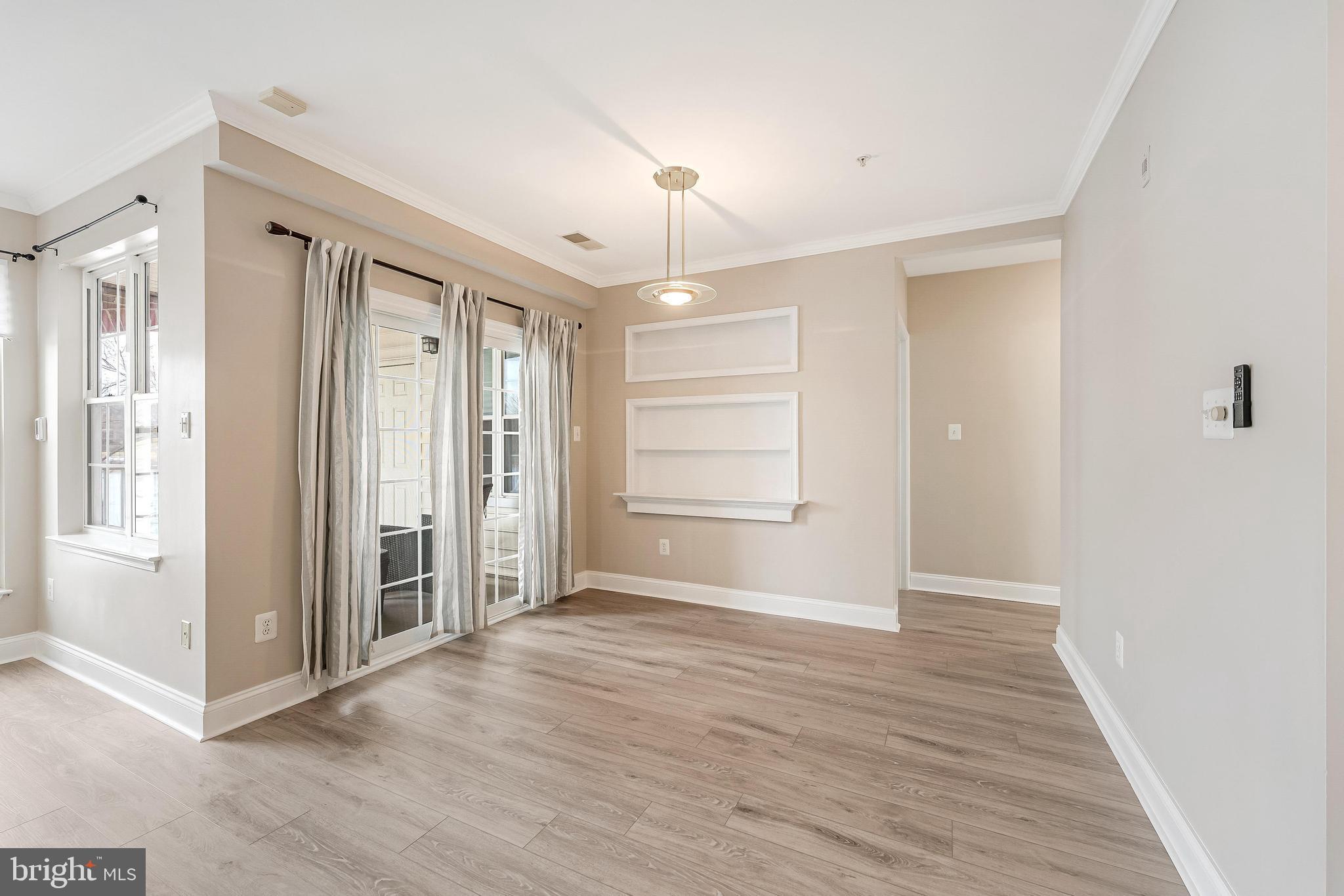 25280 Lake Shore Square, Unit 102 Chantilly, VA 20152 - Photo 10 of 41 a view of an empty room with wooden floor and a window