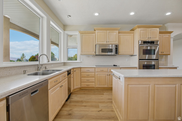 220 East Ridge Road Orem, UT 84057 - Photo 8 of 52 Contemporary kitchen featuring light wood cabinetry, stainless steel appliances, a center island, and wood-finish flooring