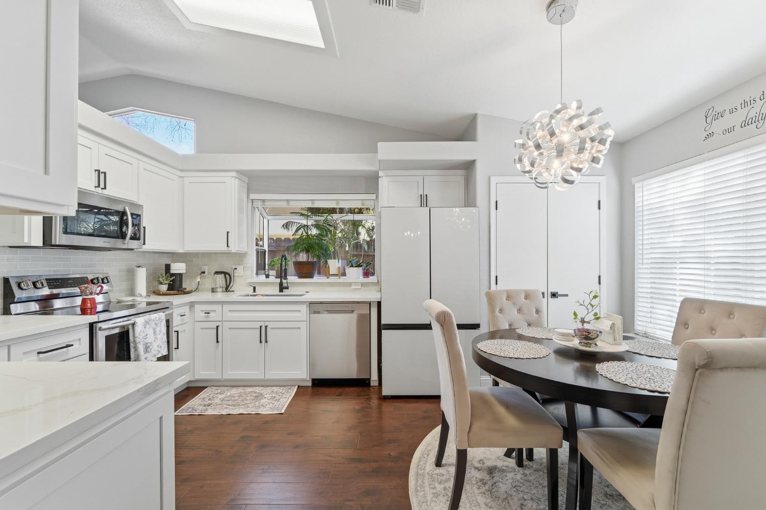 3409 Friar Tuck Way Modesto, CA 95355 - Photo 11 of 46 a kitchen with a dining table chairs and white cabinets