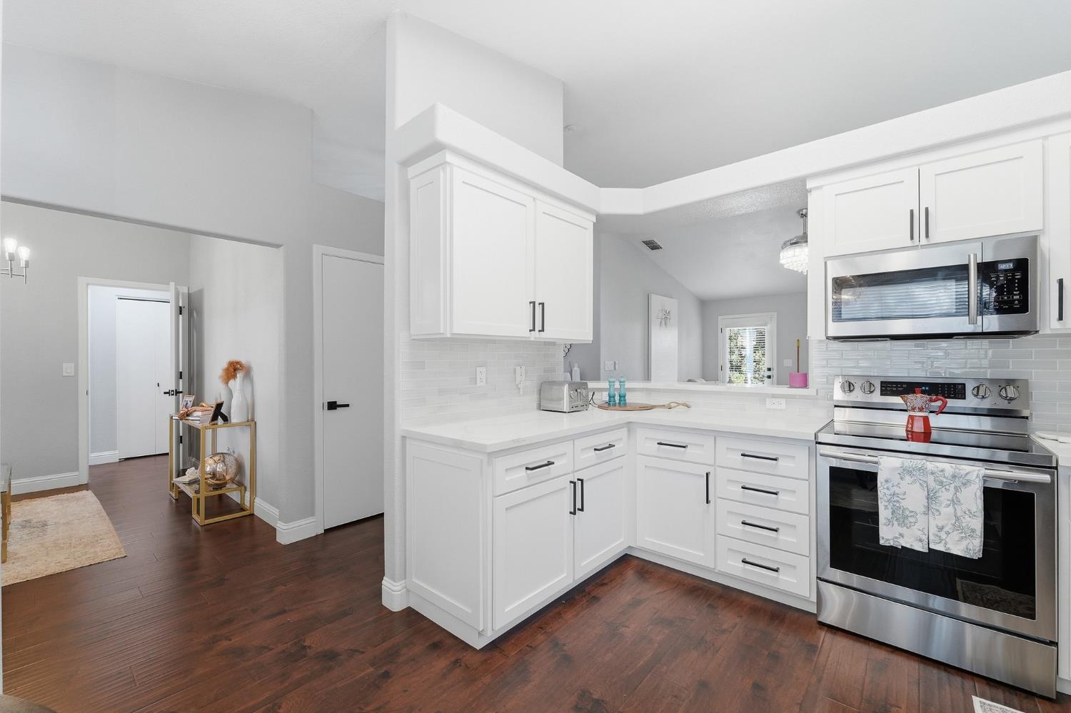 3409 Friar Tuck Way Modesto, CA 95355 - Photo 16 of 46 a kitchen with stainless steel appliances granite countertop a stove top oven a sink dishwasher and white cabinets with wooden floor