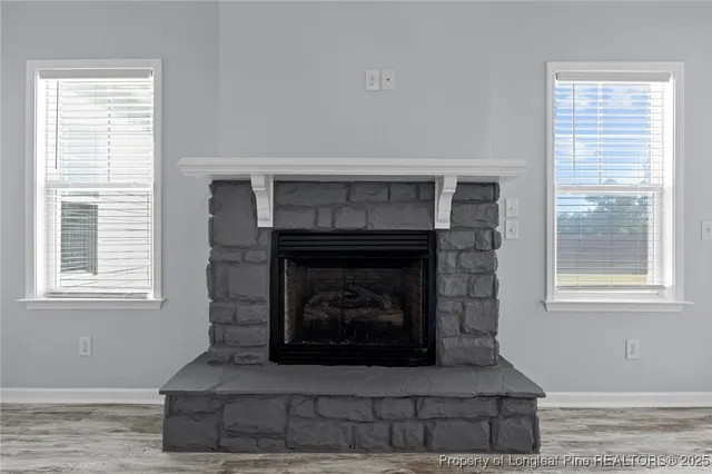 a living room with a fireplace and windows