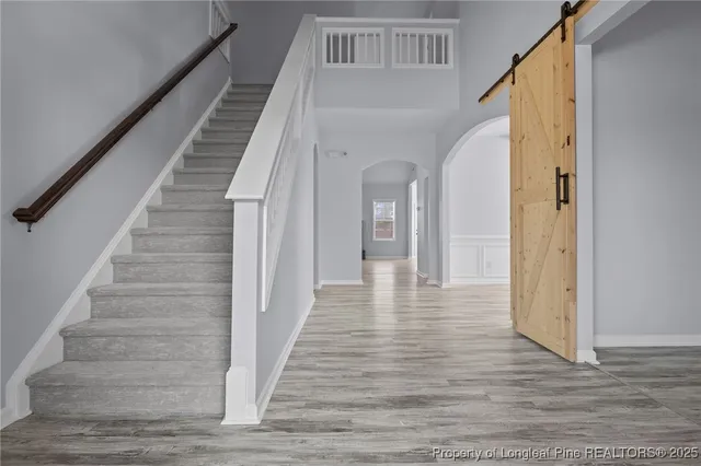 a view of staircase with wooden floor and white walls