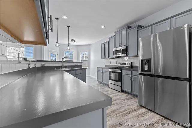 a kitchen with stainless steel appliances a refrigerator sink and stove