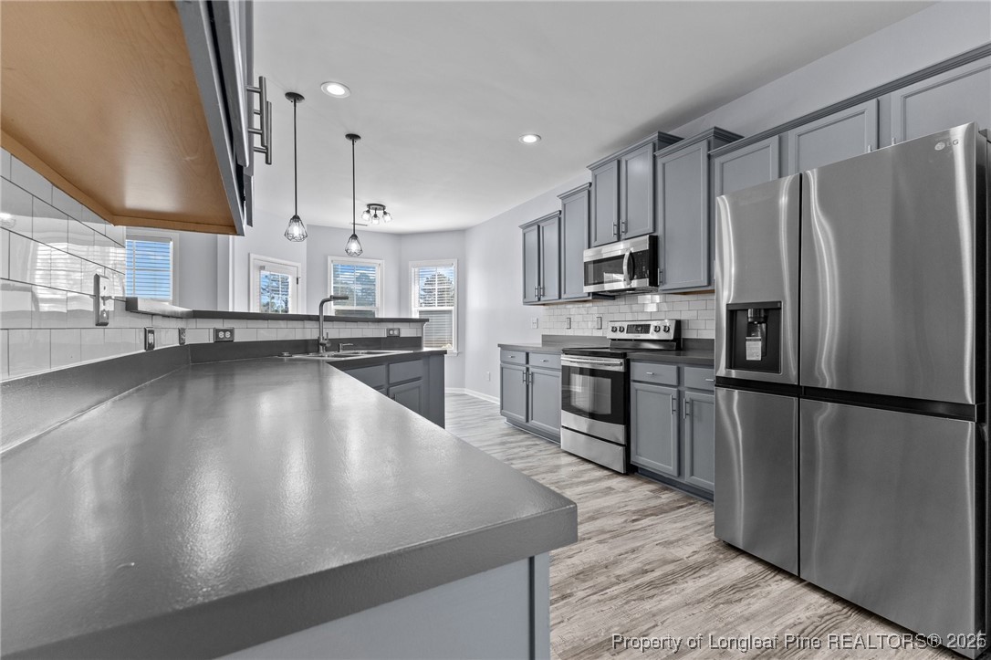 12 Turnbridge Way Spring Lake, NC 28390 - Photo 8 of 46 a kitchen with stainless steel appliances a refrigerator sink and stove