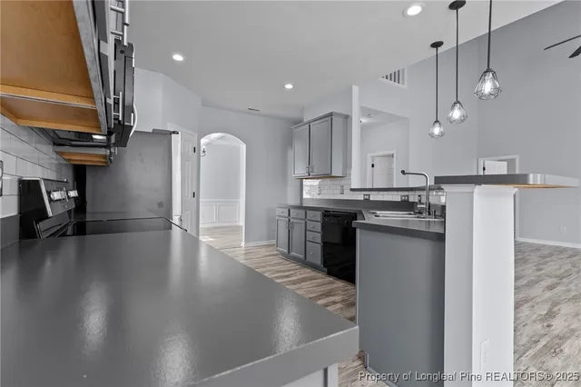 a kitchen with kitchen island a counter top space a sink stainless steel appliances and cabinets
