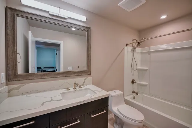 a bathroom with a sink a toilet a mirror and shower