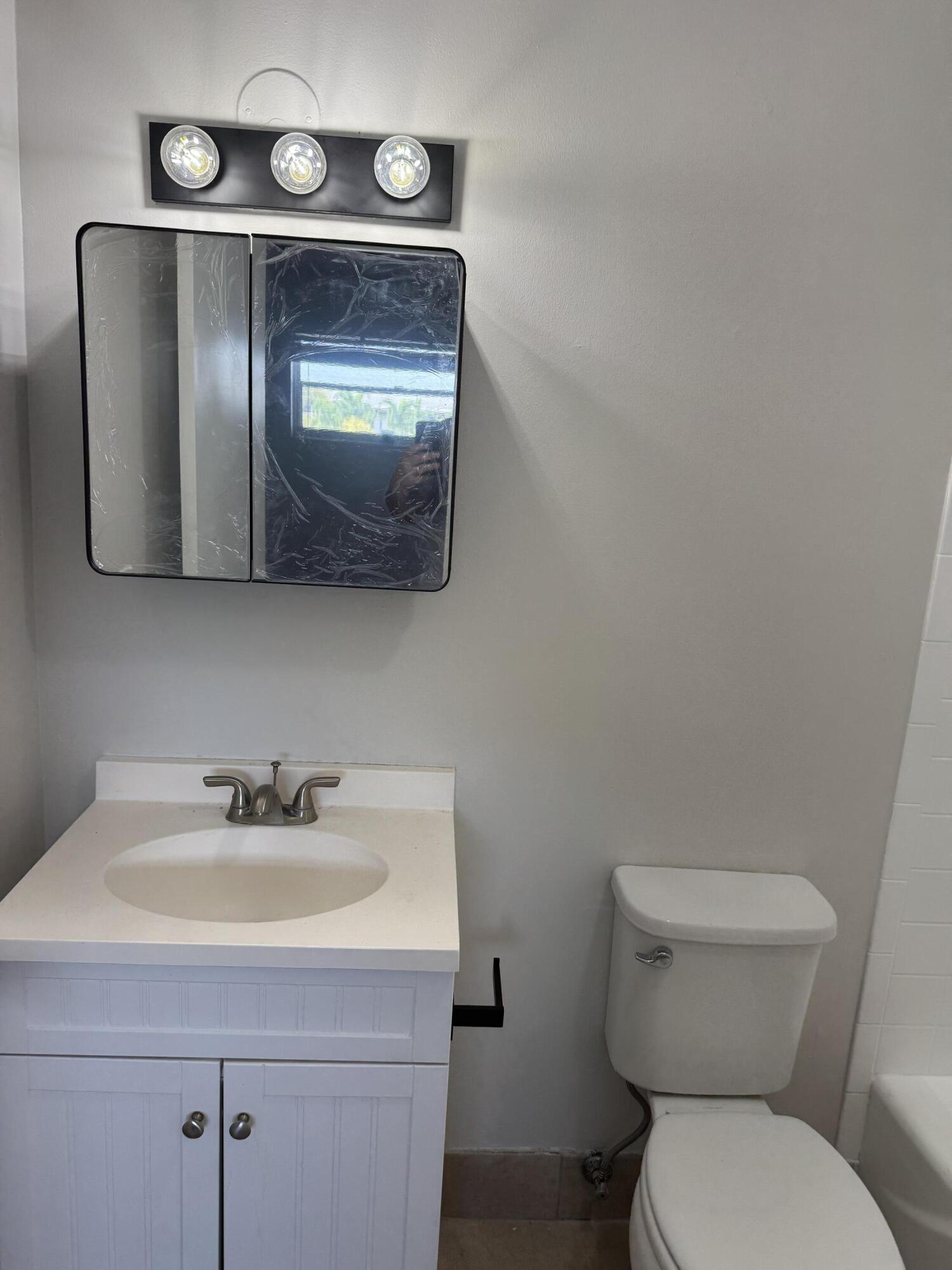 420 West Palm Street, Unit 4 Lantana, FL 33462 - Photo 11 of 21 a bathroom with a toilet sink and mirror