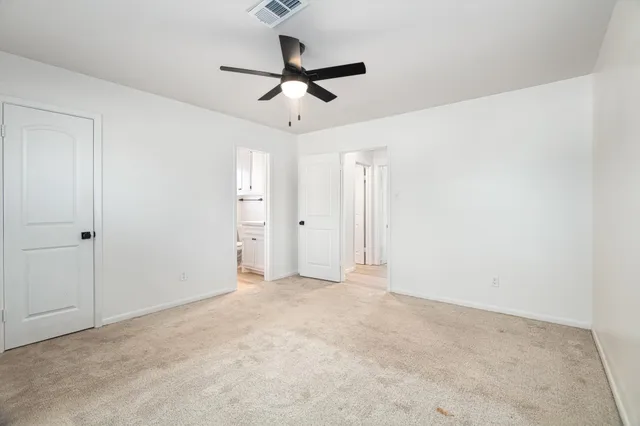 an empty room with a ceiling fan and window