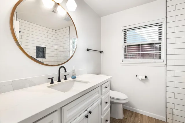 a bathroom with a sink a toilet and a mirror