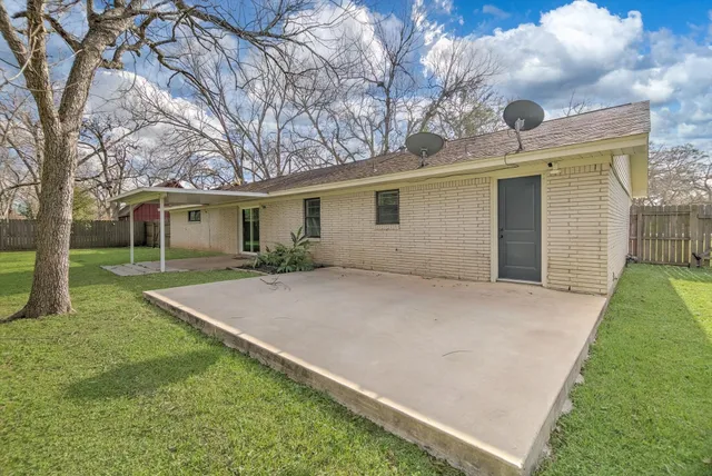 a view of an house with backyard space and tree