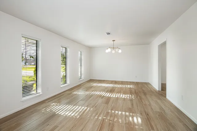 wooden floor in an empty room with a window