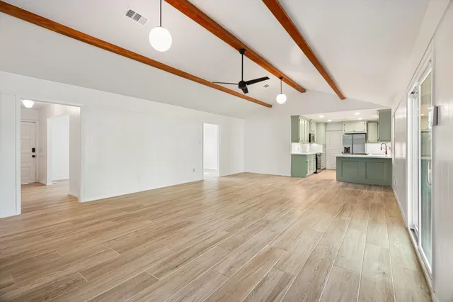 a view of empty room with wooden floor