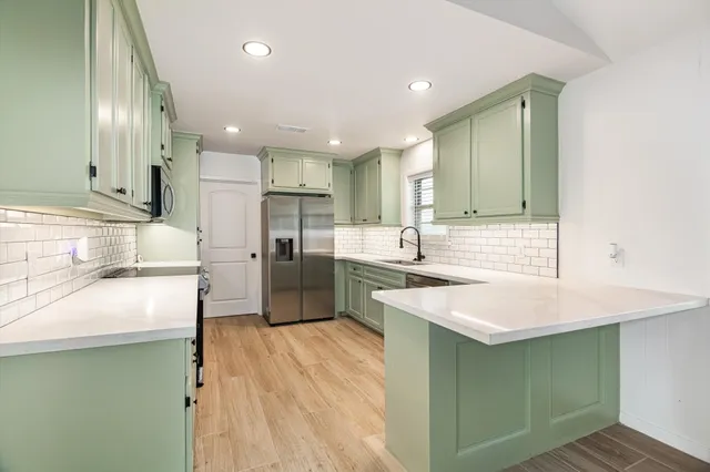 a kitchen with stainless steel appliances sink refrigerator and microwave