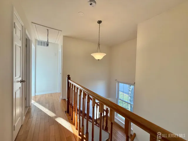 a view of a hallway with wooden floor and staircase