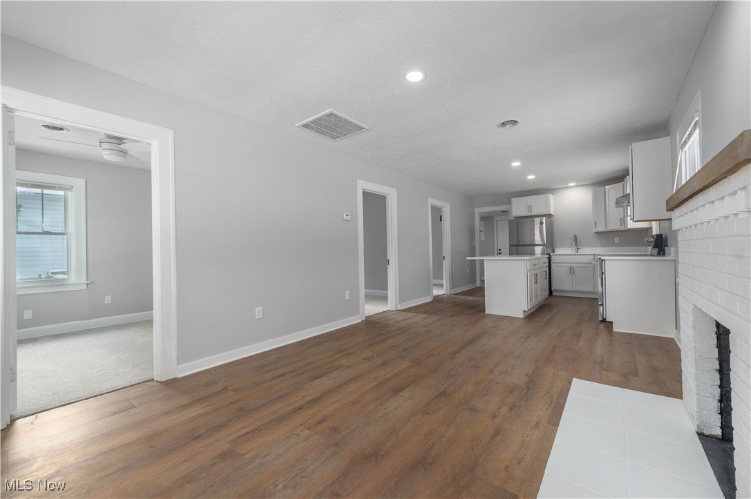 218 Roxboro Road Vermilion, OH 44089 - Photo 11 of 50 Unfurnished living room with a brick fireplace, dark wood-style flooring, and recessed lighting