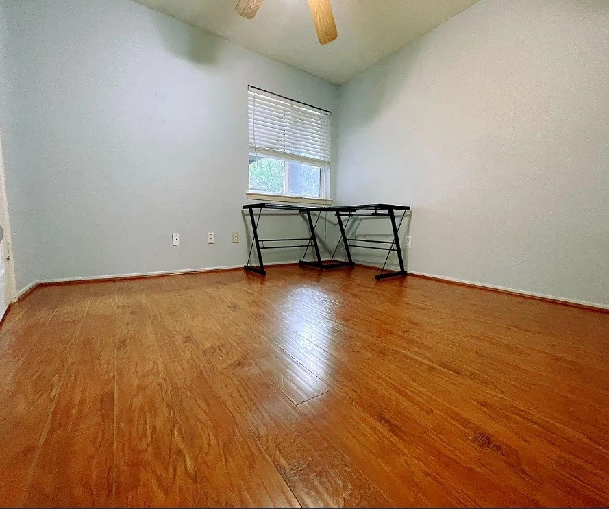 1906 Woodstream Boulevard Sugar Land, TX 77479 - Photo 6 of 14 an empty room with wooden floor and windows