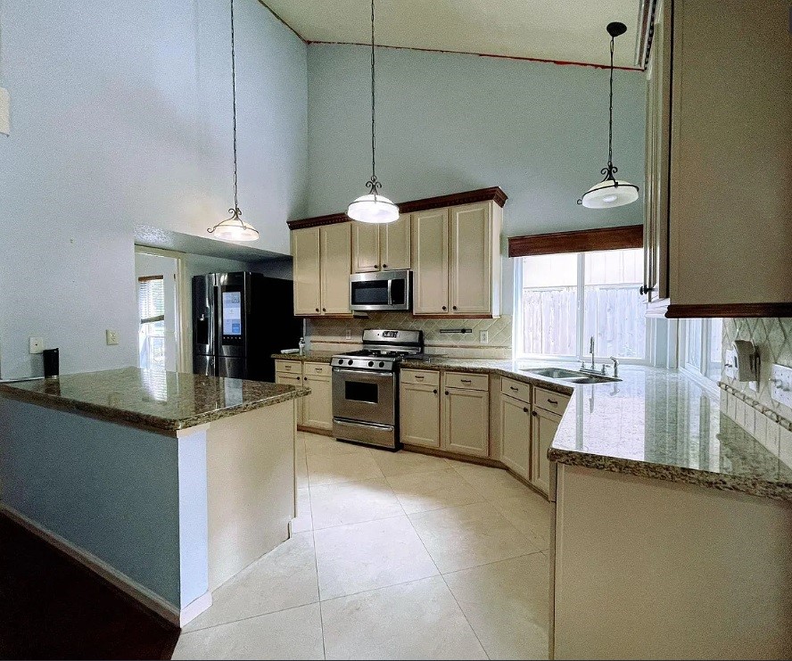 1906 Woodstream Boulevard Sugar Land, TX 77479 - Photo 9 of 14 a kitchen with stainless steel appliances granite countertop a sink a stove and a refrigerator