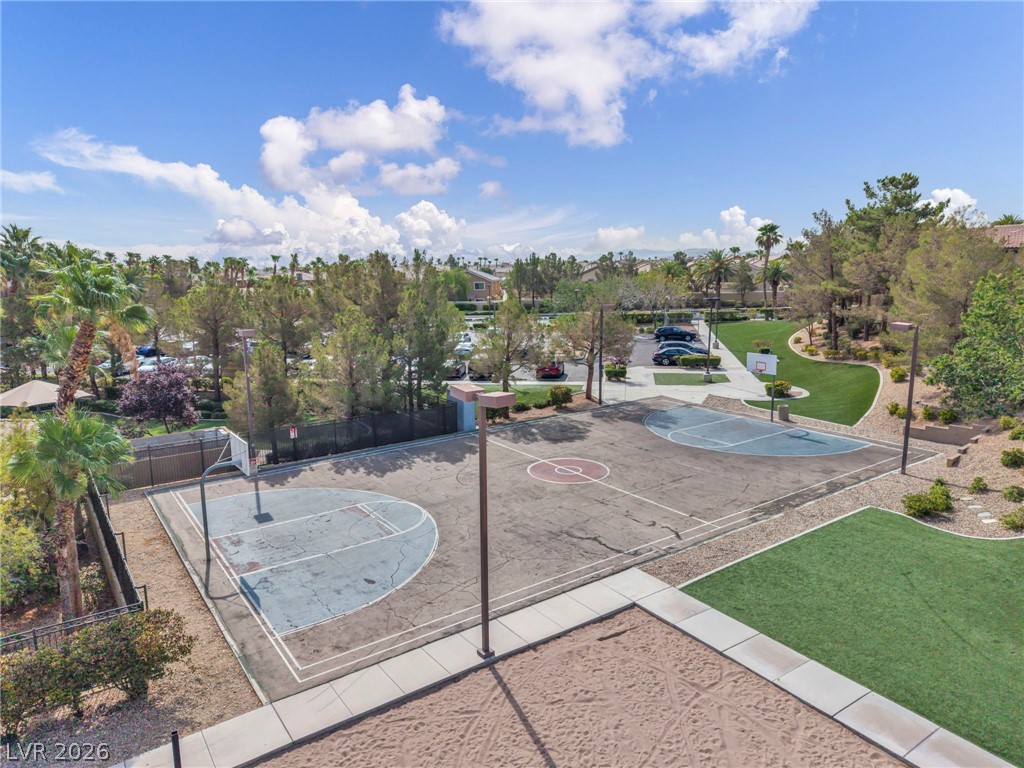 389 Fringe Ruff Drive Las Vegas, NV 89148 - Photo 44 of 53 An outdoor basketball court stands surrounded by manicured lawns and lush desert landscaping.
