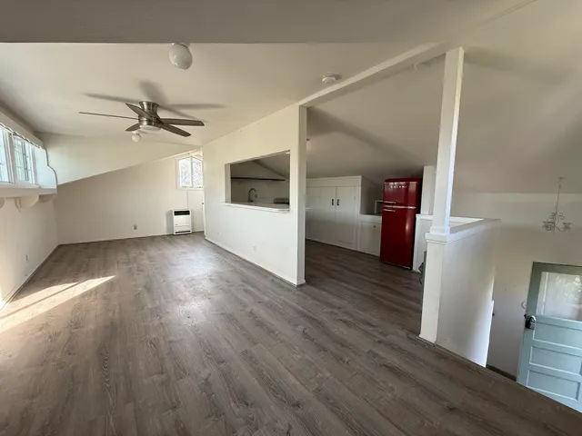 a view of a livingroom with wooden floor and a ceiling fan