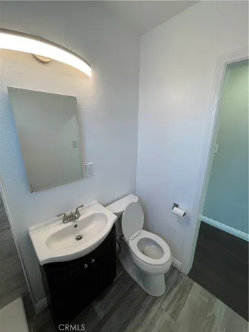 a bathroom with a toilet a sink and mirror