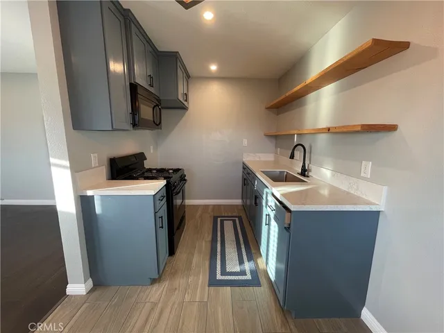 a kitchen with sink a microwave a refrigerator and wooden floor