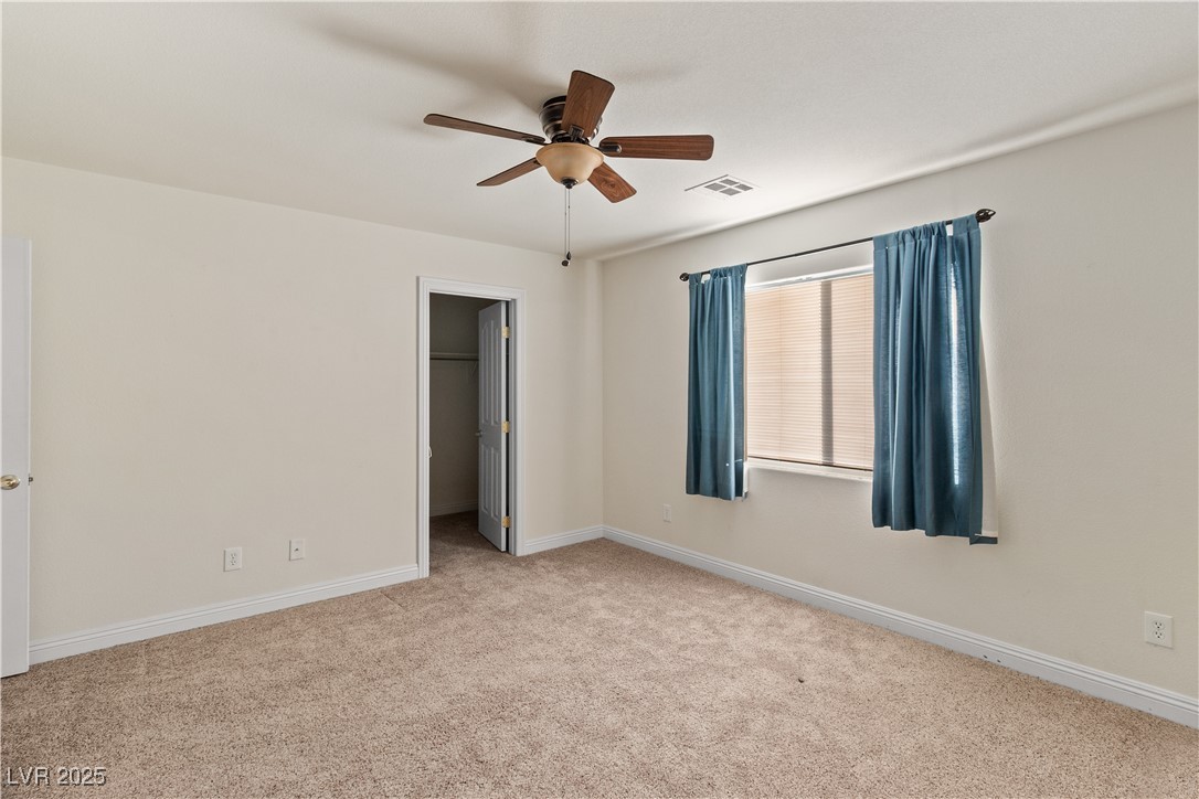 2715 Brinkley Manor Street Laughlin, NV 89029 - Photo 32 of 89 Second bedroom featuring a walk in closet, light carpet, and ceiling fan