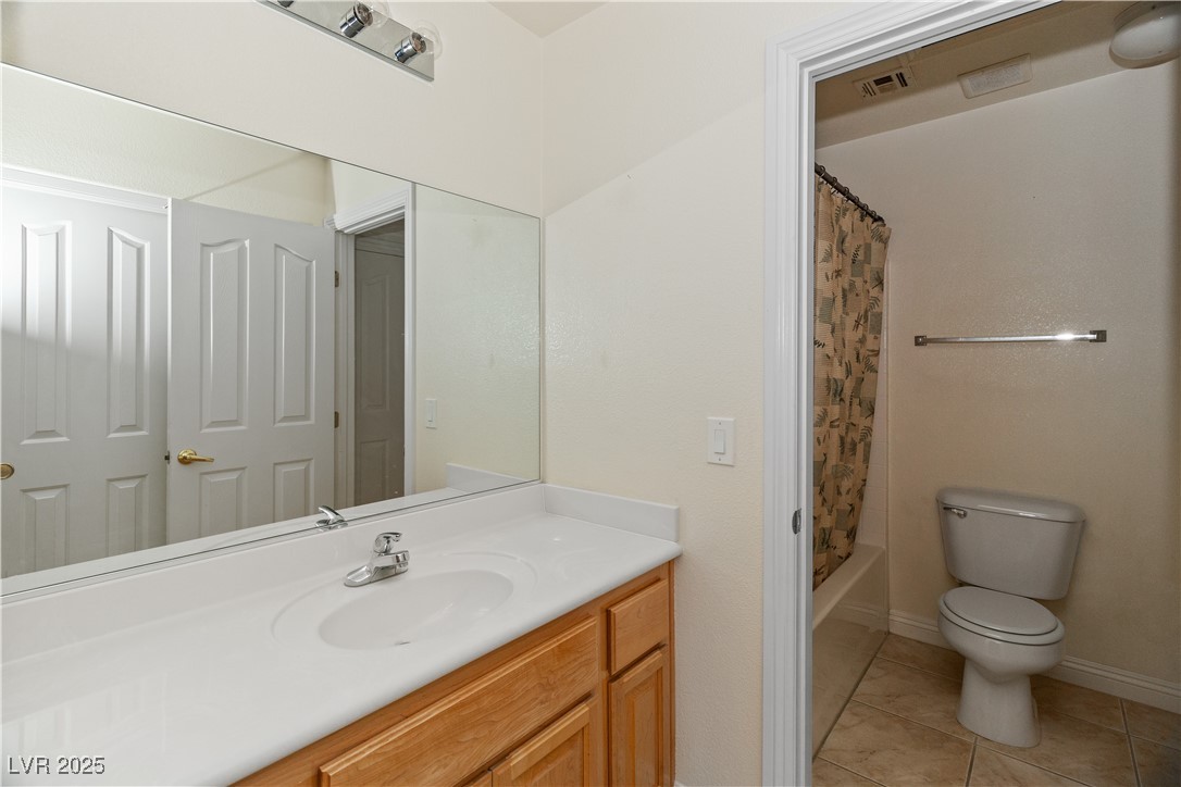 2715 Brinkley Manor Street Laughlin, NV 89029 - Photo 35 of 89 Full hall Jack-and-Jill style bathroom shared between Second Bedroom and Hallway access featuring vanity, light tile patterned floors, and shower / tub combo