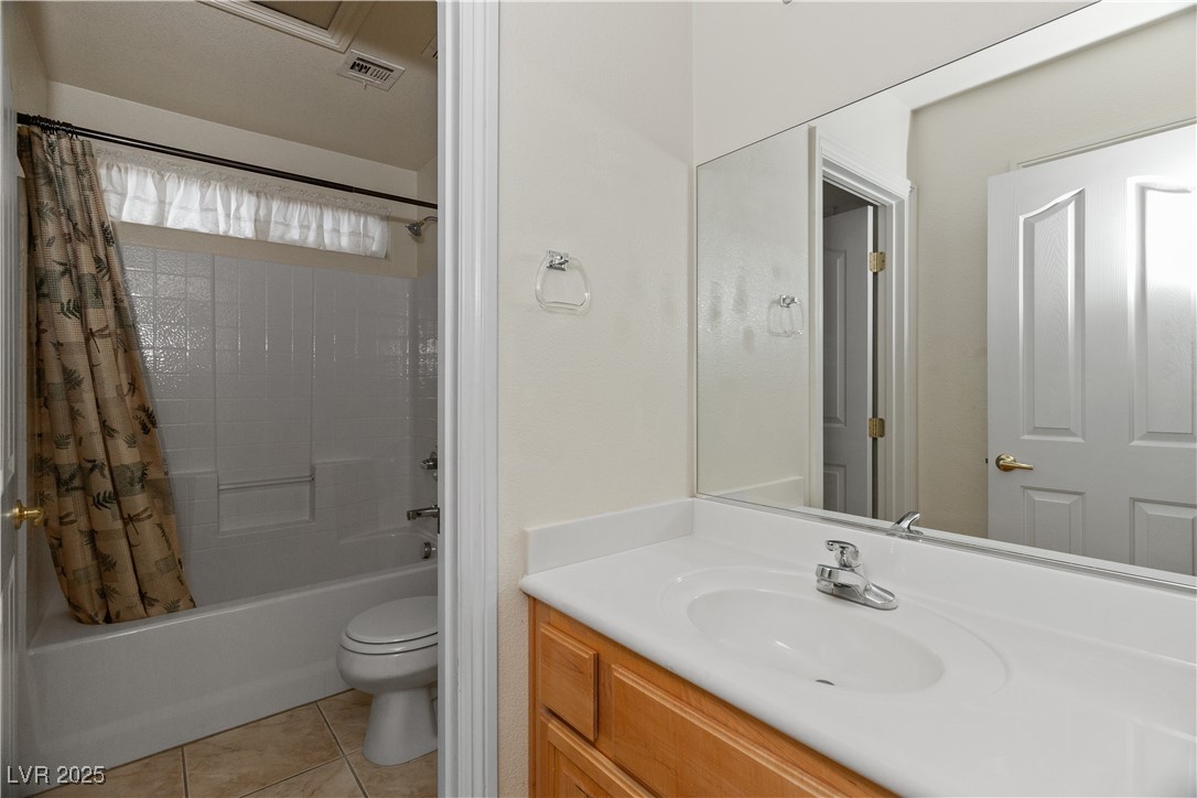 2715 Brinkley Manor Street Laughlin, NV 89029 - Photo 37 of 89 Bathroom with shower / bath combination with curtain, vanity, and light tile patterned flooring