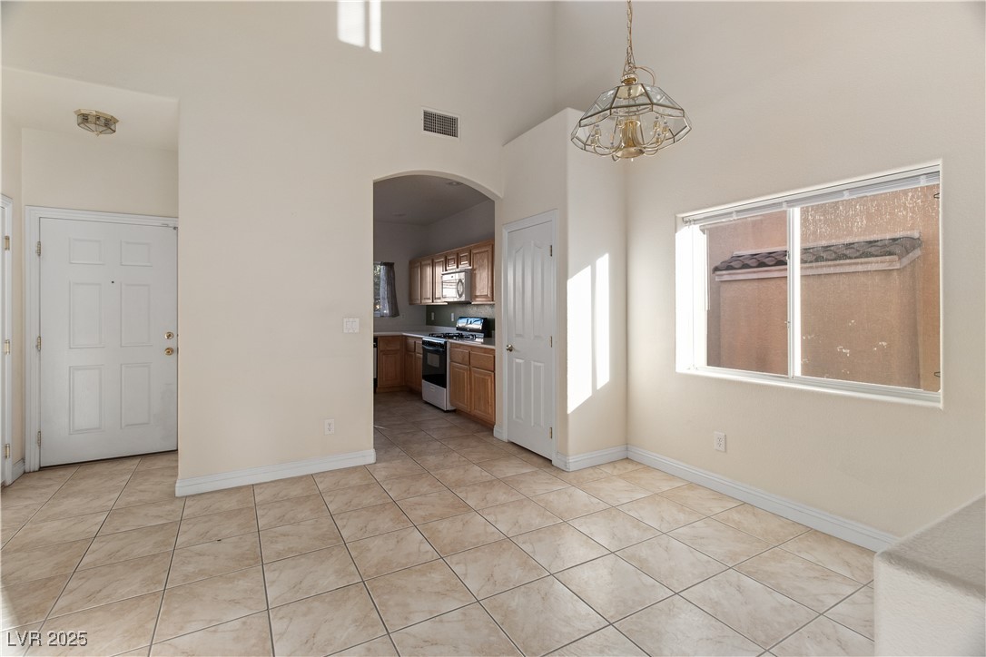 2715 Brinkley Manor Street Laughlin, NV 89029 - Photo 5 of 89 At the entry to the property you're welcomed with the Dining area with light tile patterned floors and hanging light fixture