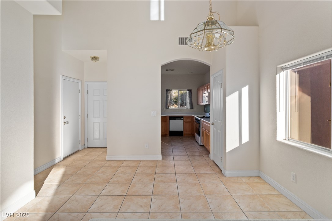 2715 Brinkley Manor Street Laughlin, NV 89029 - Photo 6 of 89 Dining area to Kitchen featuring arched walkways, pendant lighting, light tile patterned flooring, dishwasher, and range with gas stovetop