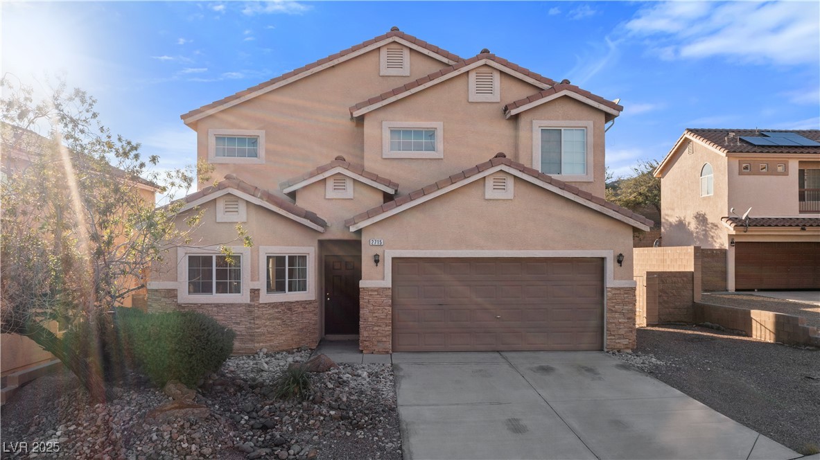 2715 Brinkley Manor Street Laughlin, NV 89029 - Photo 69 of 89 View of front of house with stone siding, stucco siding, concrete driveway, and a tiled roof