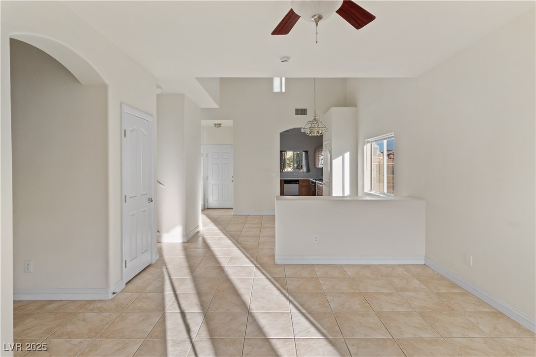 2715 Brinkley Manor Street Laughlin, NV 89029 - Photo 8 of 89 Living room featuring arched walkways, a ceiling fan, light tile patterned floors, and a high ceiling